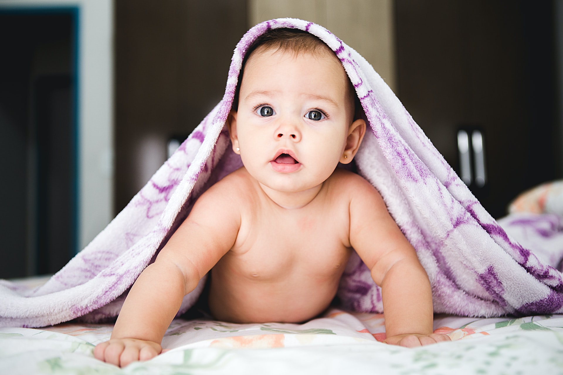 Cute baby crawling with blanket on head